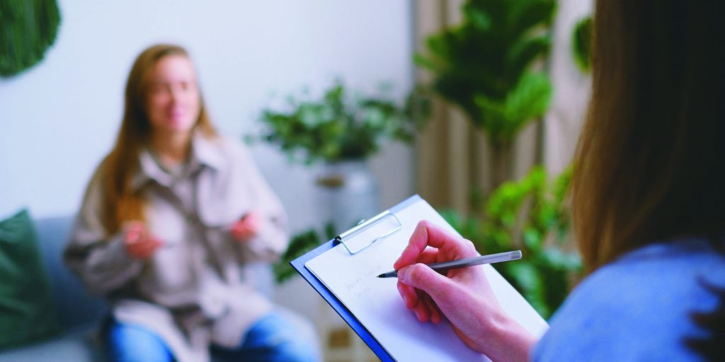 Woman with doctor completes post-treatment assessment